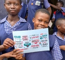 Schoolgirl holding a menstrual health awareness card